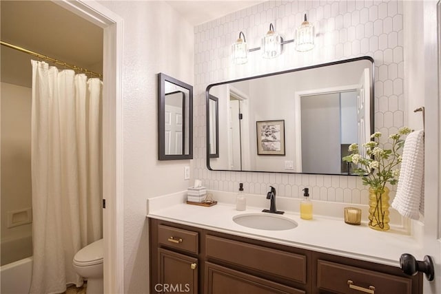 bathroom featuring toilet, shower / bath combo with shower curtain, and vanity