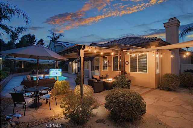 exterior space with an outdoor living space with a fire pit and an outdoor pool