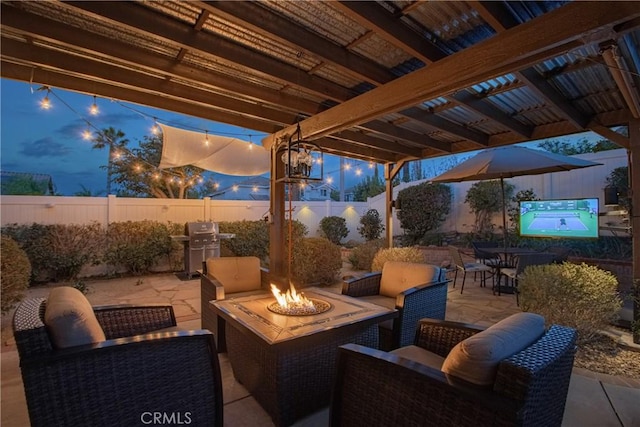 view of patio featuring grilling area, an outdoor fire pit, and a fenced backyard