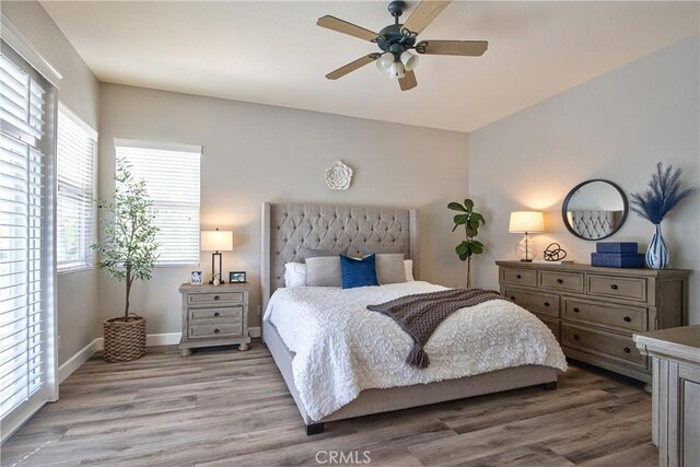 bedroom with wood finished floors, ceiling fan, and baseboards