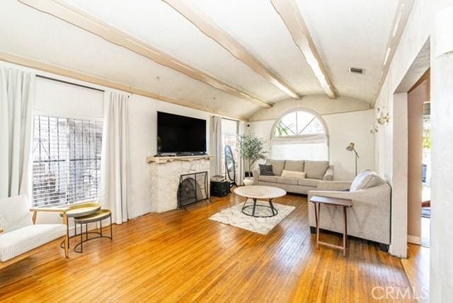 6114 Allston St, Los Angeles, CA 90022 - living area featuring a fireplace, wood finished floors, visible vents, and lofted ceiling with beams