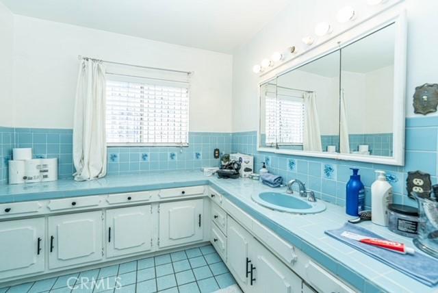 6114 Allston St, Los Angeles, CA 90022 - bathroom with tile walls, tile patterned floors, and a sink