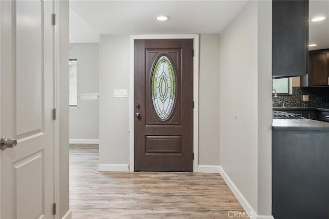 foyer with recessed lighting, light wood-style floors, and baseboards