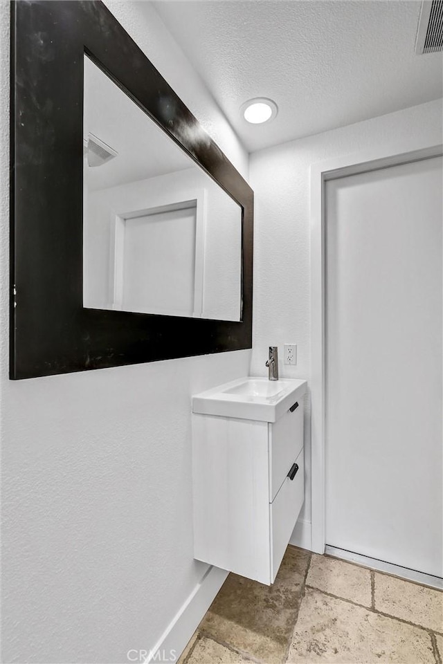 334 Tours Ln, Costa Mesa, CA 92627 - bathroom featuring vanity, a textured ceiling, and stone tile floors