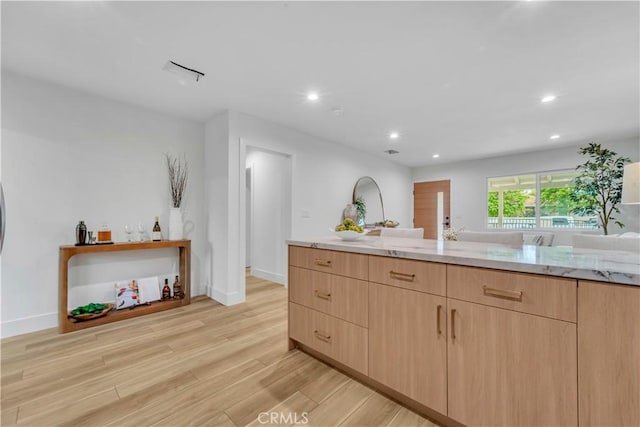 8519 Wakefield Ave, Panorama City, CA 91402 - kitchen with light stone countertops, light brown cabinets, recessed lighting, and light wood-style floors