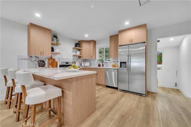 8519 Wakefield Ave, Panorama City, CA 91402 - kitchen featuring light countertops, open shelves, light wood-style floors, a peninsula, and appliances with stainless steel finishes
