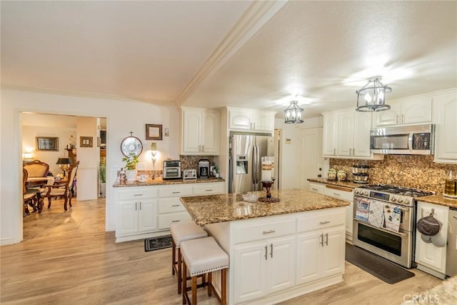 9527 Manzanita Dr, Rancho Cucamonga, CA 91737 - kitchen with stainless steel appliances, a kitchen island, crown molding, decorative backsplash, and a chandelier