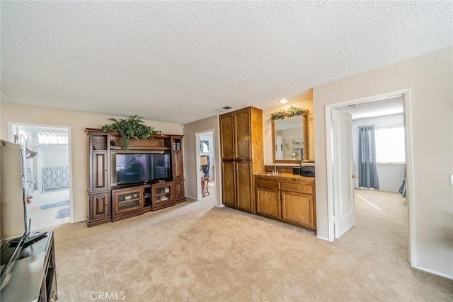 9527 Manzanita Dr, Rancho Cucamonga, CA 91737 - living area with a wealth of natural light, visible vents, a textured ceiling, and light colored carpet