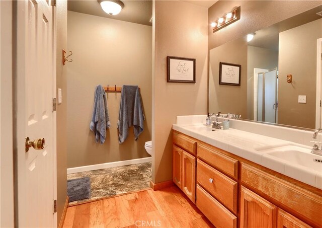 41820 Dillon Cir, Ahwahnee, CA 93601 - full bathroom featuring wood finished floors, toilet, double vanity, and a shower with shower door
