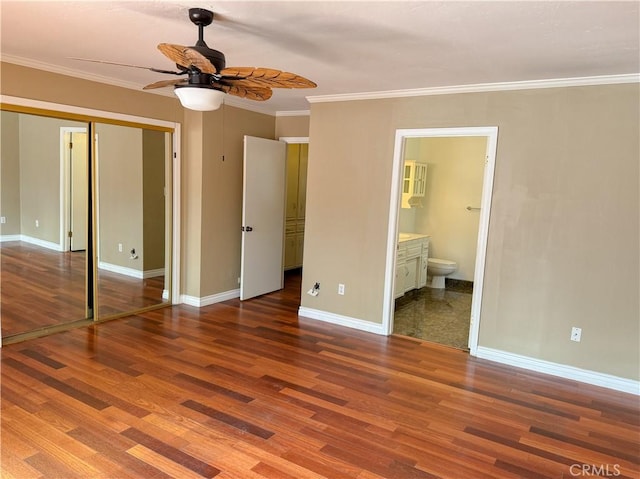 unfurnished bedroom with wood finished floors, baseboards, a closet, and crown molding
