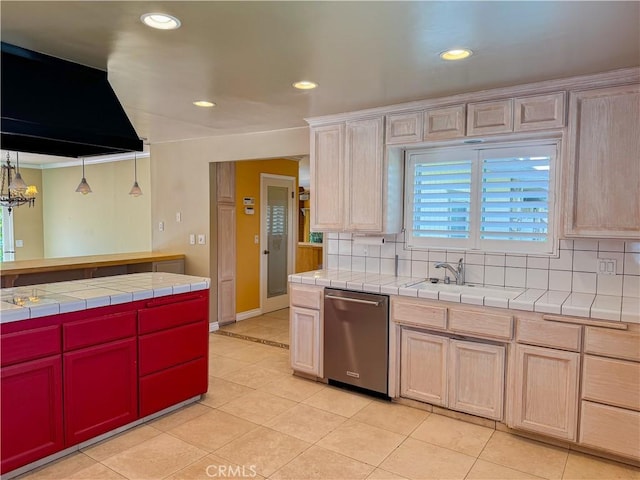 kitchen with tile countertops, backsplash, stainless steel dishwasher, and a sink