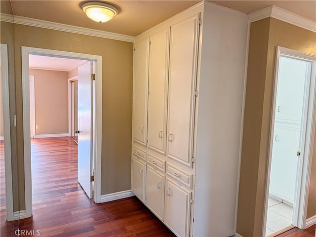 corridor with baseboards, dark wood-style floors, and ornamental molding