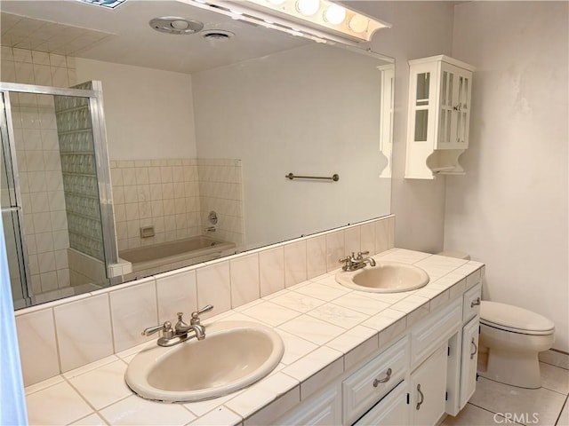 bathroom with a garden tub, toilet, a sink, and a stall shower