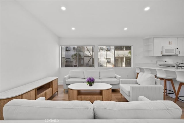 living room featuring recessed lighting, light wood finished floors, and baseboards