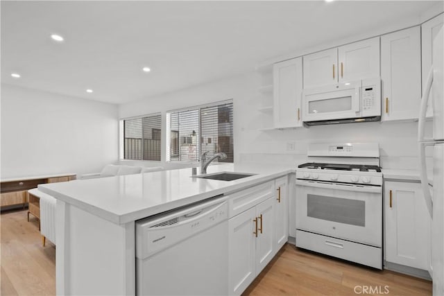 kitchen with white cabinetry, a sink, white appliances, and recessed lighting