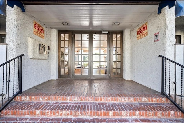 property entrance with french doors and stucco siding