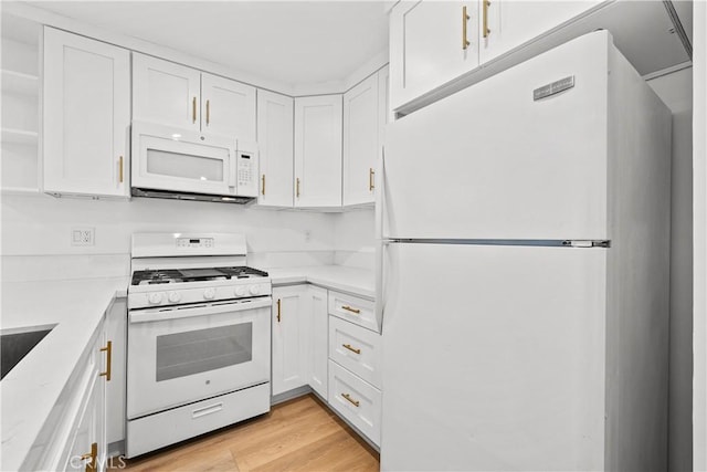 kitchen with light countertops, white cabinetry, and white appliances