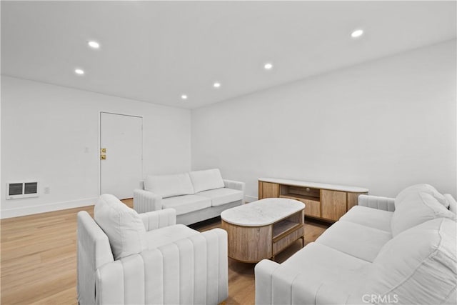 living area with recessed lighting, light wood-type flooring, visible vents, and baseboards