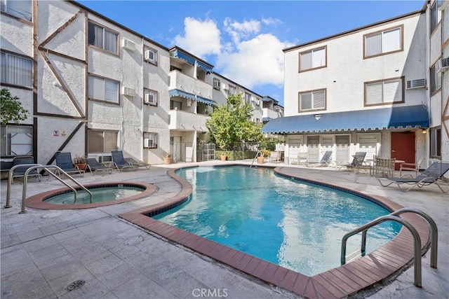 community pool with a community hot tub and a patio