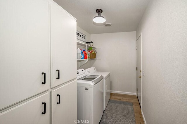6030 Treehaven Ct, Lancaster, CA 93536 - washroom with washing machine and clothes dryer, cabinet space, light wood-style floors, and baseboards