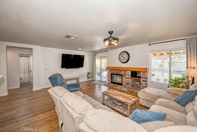 6030 Treehaven Ct, Lancaster, CA 93536 - living room with wood finished floors, a brick fireplace, and baseboards