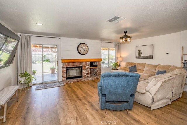 6030 Treehaven Ct, Lancaster, CA 93536 - living area with a fireplace, light wood-style flooring, and a ceiling fan