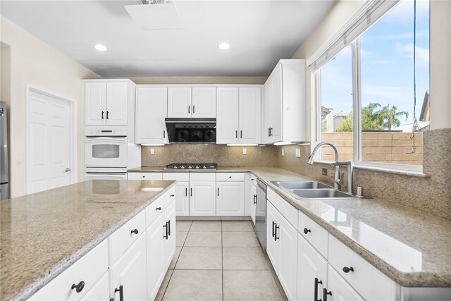 13608 Sagemont Ct, Eastvale, CA 92880 - kitchen with stainless steel gas cooktop, light tile patterned flooring, decorative backsplash, white cabinetry, and recessed lighting