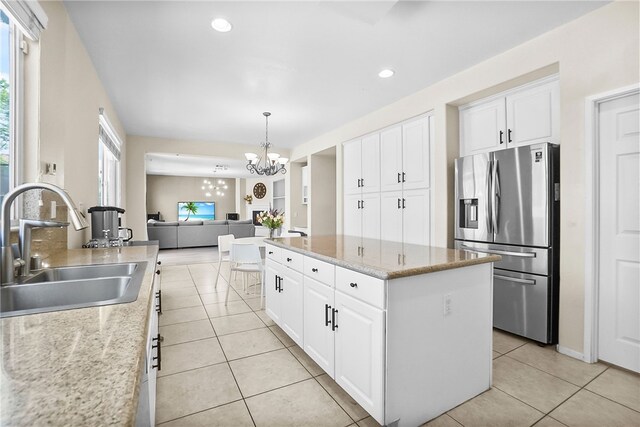 13608 Sagemont Ct, Eastvale, CA 92880 - kitchen with stainless steel fridge with ice dispenser, light tile patterned flooring, a center island, open floor plan, and white cabinets