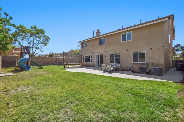 13608 Sagemont Ct, Eastvale, CA 92880 - back of house featuring a trampoline, a patio, stucco siding, a fenced backyard, and a playground