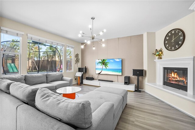 13608 Sagemont Ct, Eastvale, CA 92880 - living room with a chandelier, light wood finished floors, and a glass covered fireplace
