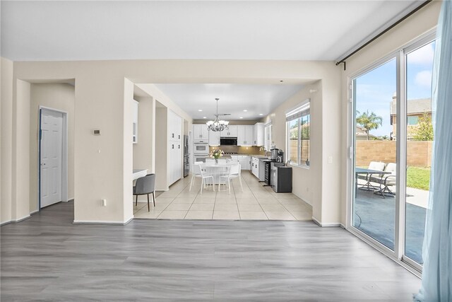 13608 Sagemont Ct, Eastvale, CA 92880 - kitchen featuring a chandelier, light wood finished floors, white cabinets, a kitchen breakfast bar, and recessed lighting