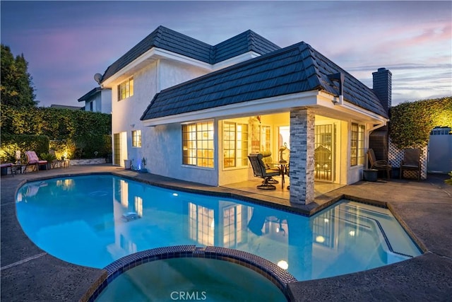 3010 Stoner Ave, Los Angeles, CA 90066 - back of property at dusk featuring an exterior structure, an outbuilding, a patio, stucco siding, and a pool with connected hot tub