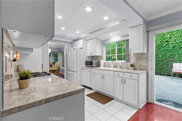 3010 Stoner Ave, Los Angeles, CA 90066 - kitchen with tasteful backsplash, a sink, stainless steel appliances, white cabinets, and ornamental molding