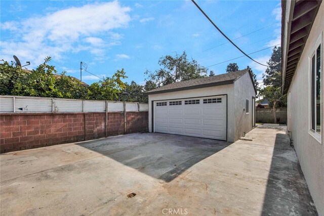 detached garage featuring fence