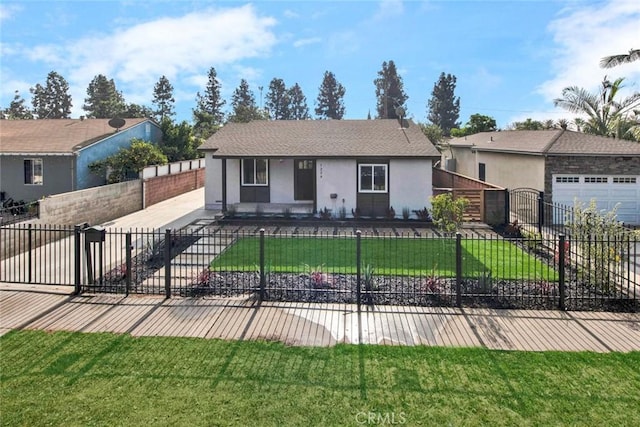 view of front of property with a fenced front yard, a front lawn, stucco siding, an attached garage, and driveway