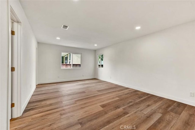 unfurnished room featuring light wood finished floors, baseboards, visible vents, and recessed lighting
