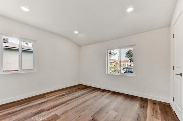 empty room with recessed lighting, a wealth of natural light, wood finished floors, and baseboards