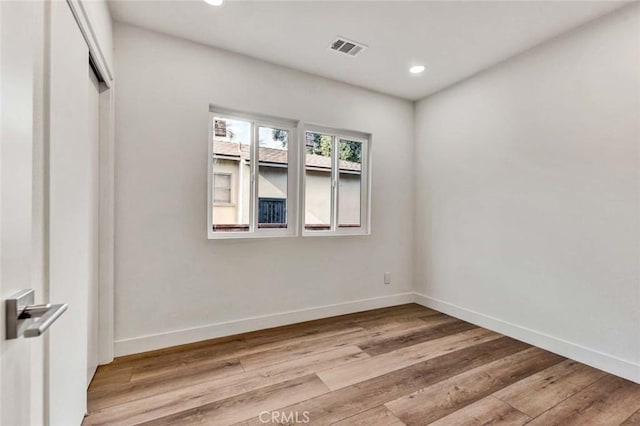 unfurnished room featuring light wood finished floors, baseboards, visible vents, and recessed lighting