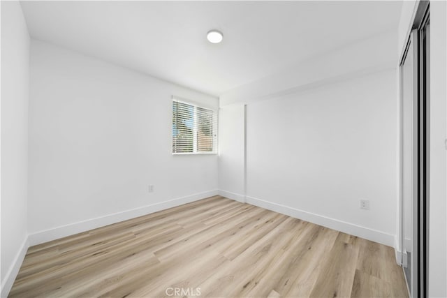 3721 S San Pedro St, Los Angeles, CA 90011 - unfurnished bedroom with baseboards, a closet, and light wood-style flooring