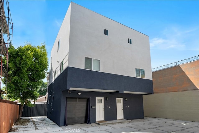 3721 S San Pedro St, Los Angeles, CA 90011 - contemporary home featuring an attached garage, stucco siding, and fence