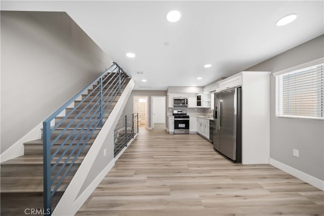 3721 S San Pedro St, Los Angeles, CA 90011 - kitchen with white cabinets, light wood-style flooring, baseboards, recessed lighting, and appliances with stainless steel finishes