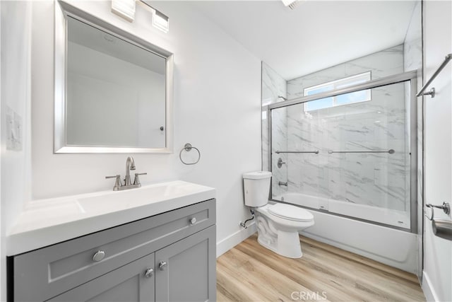 3721 S San Pedro St, Los Angeles, CA 90011 - full bathroom with wood finished floors, vanity, baseboards, enclosed tub / shower combo, and toilet