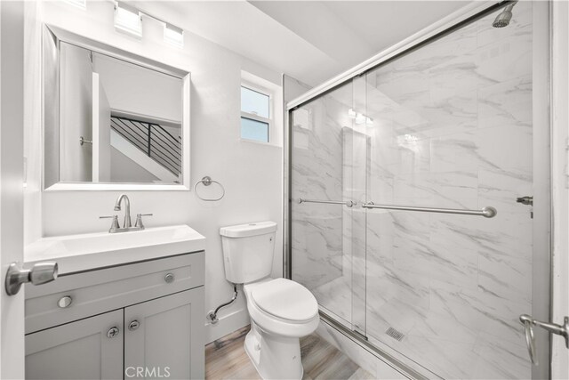 3721 S San Pedro St, Los Angeles, CA 90011 - full bathroom featuring wood finished floors, toilet, vanity, and a marble finish shower