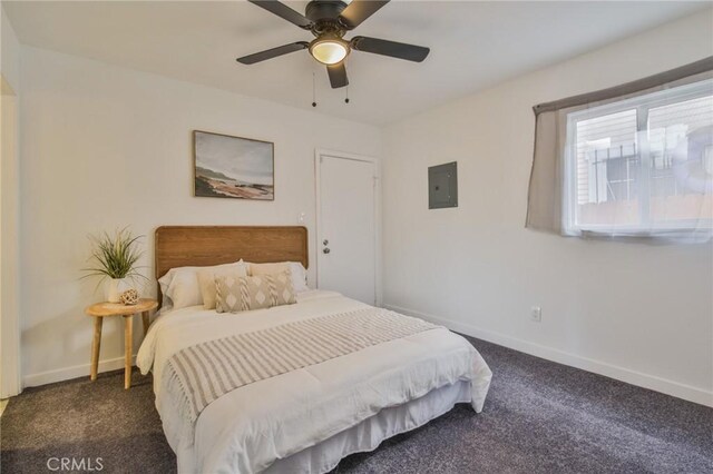 bedroom with electric panel, dark colored carpet, baseboards, and a ceiling fan