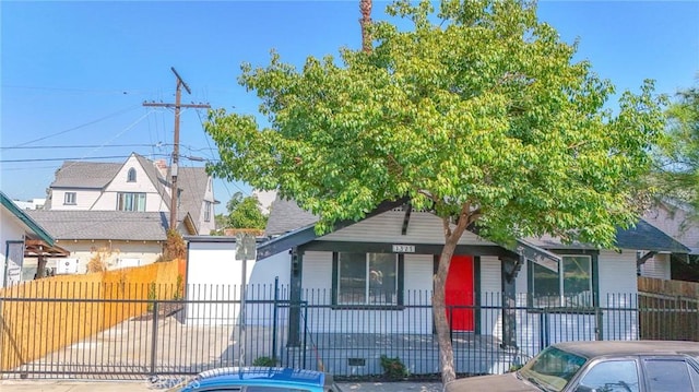 bungalow-style home with a porch, crawl space, and a fenced front yard