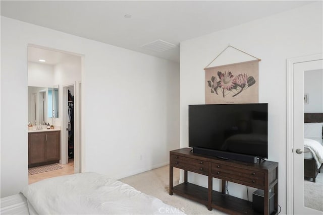bedroom with visible vents, a sink, and connected bathroom