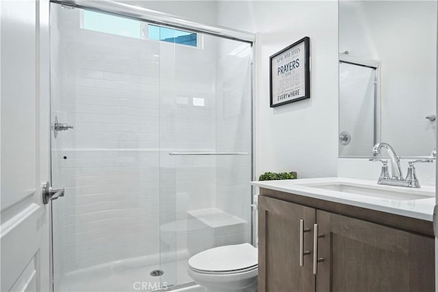 bathroom with vanity, toilet, and a stall shower