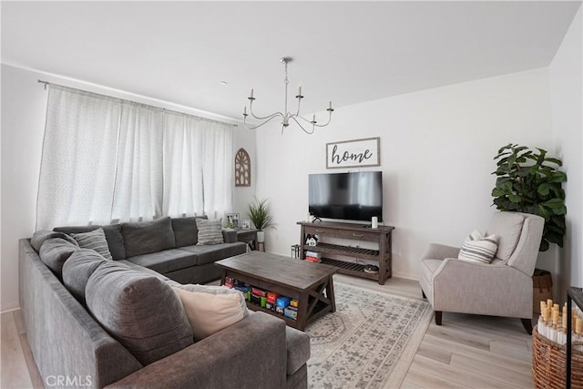 living room with light wood-type flooring, baseboards, and a chandelier