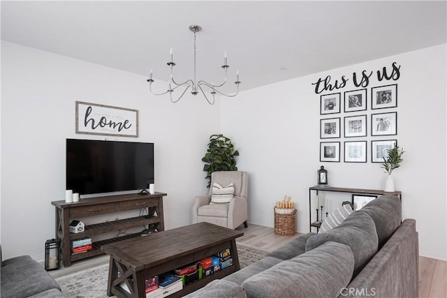 living room with light wood-style floors and a notable chandelier