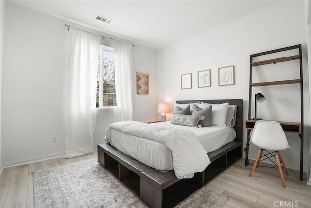 bedroom with baseboards, light wood-style flooring, and visible vents